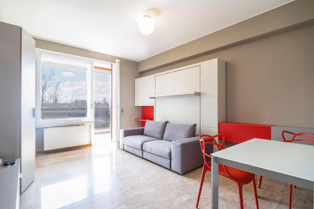 ein Wohnzimmer mit einem Sofa und einem Tisch in der Unterkunft Contempora Apartments - Elvezia 8 - E33 in Mailand