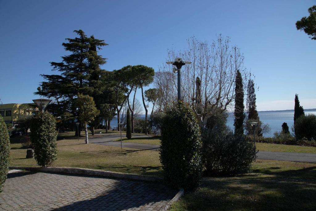 un parc avec des buissons et une lumière de rue et l'océan dans l'établissement Lato soleggiato @Gardazzurro, à Padenghe sul Garda