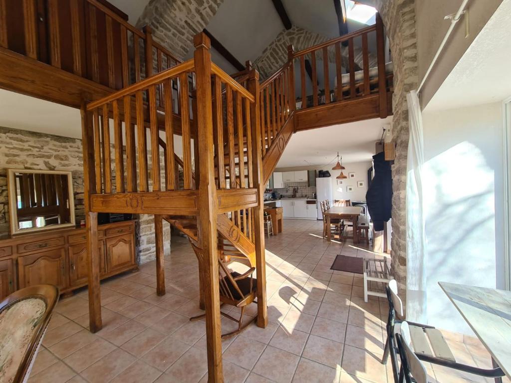 a wooden spiral staircase in a room with a kitchen at Gîte La Grange in Saint-Laurent-dʼOlt