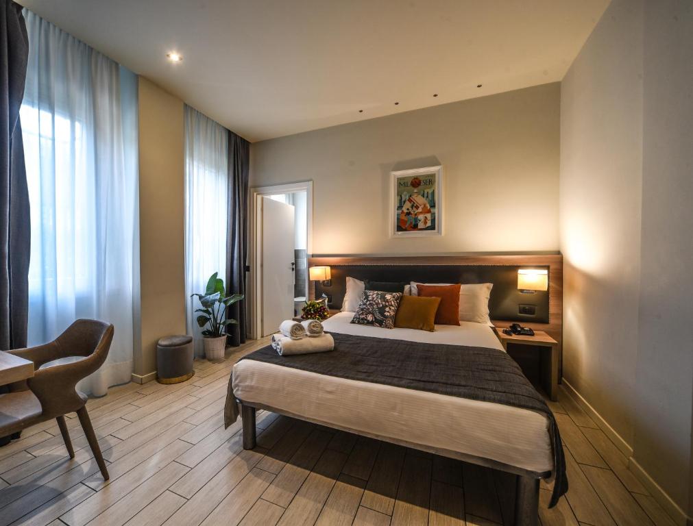 - une chambre avec un grand lit et une chaise dans l'établissement Hotel Zara Milano, à Milan