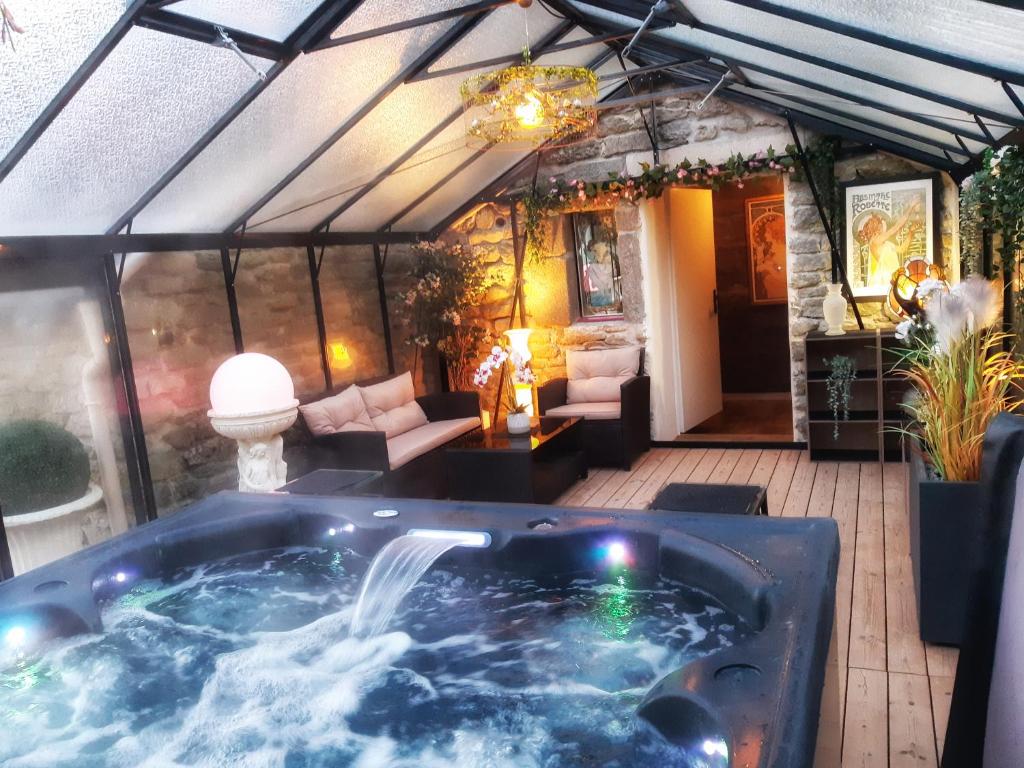 a hot tub in the middle of a patio at Nuances d'Alcôves in Trévron