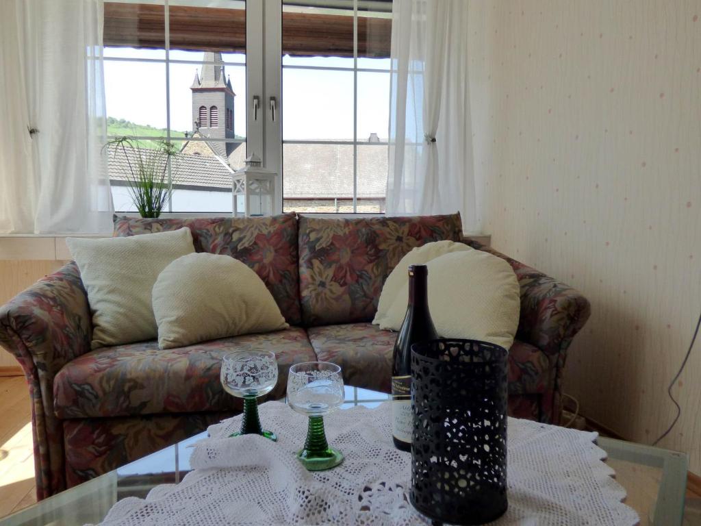 soggiorno con divano e tavolo con bicchieri da vino di Relaxen im alten Winzerhaus a Rech