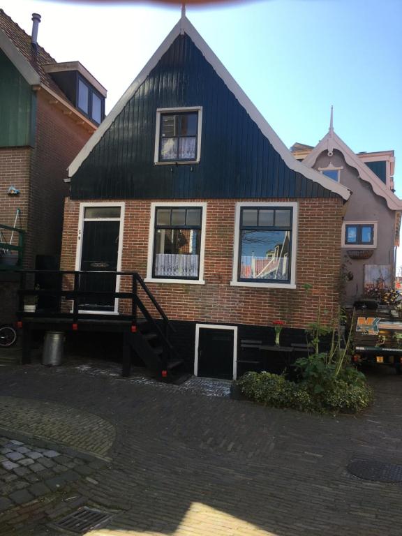 una casa con techo negro y ventanas en Family fisherman's house Volendam, en Volendam