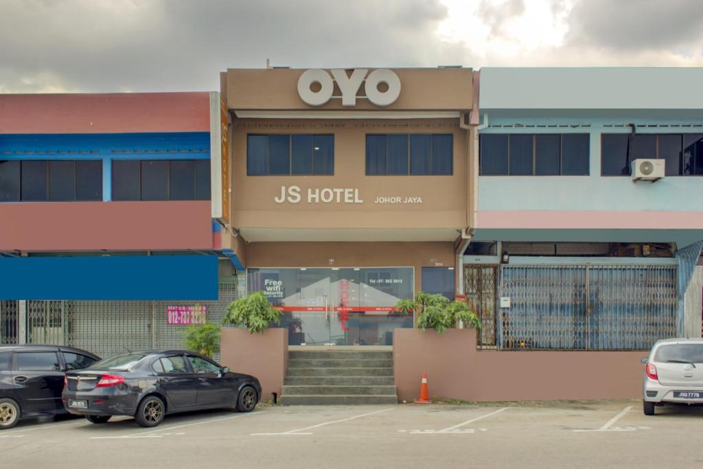 um hotel de nós com carros estacionados num parque de estacionamento em Super OYO 89985 Js Hotel em Johor Bahru