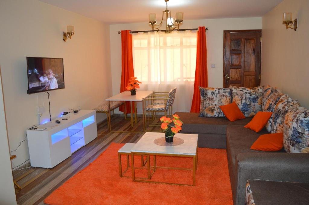 a living room with a couch and a table at Wawa Lifestyle Regency one bedroom Apartment in Nairobi