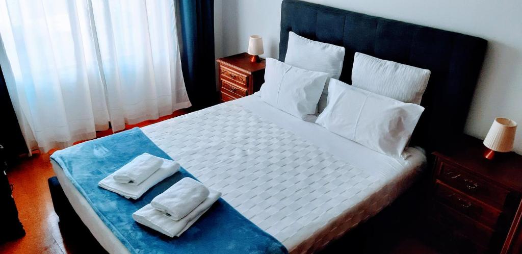 a bedroom with a large bed with two towels on it at LUCINDA`S HOUSE in Braga