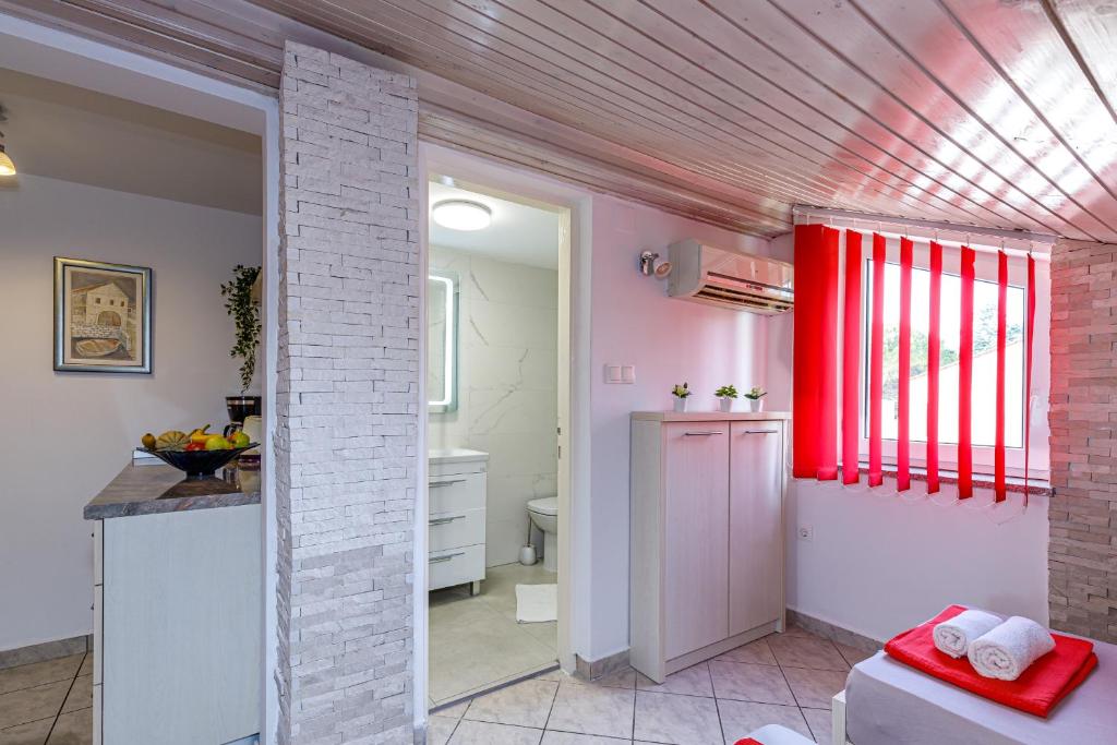 kuchnia z różowymi ścianami i czerwonym sufitem w obiekcie Apartments DIDO w Novalji