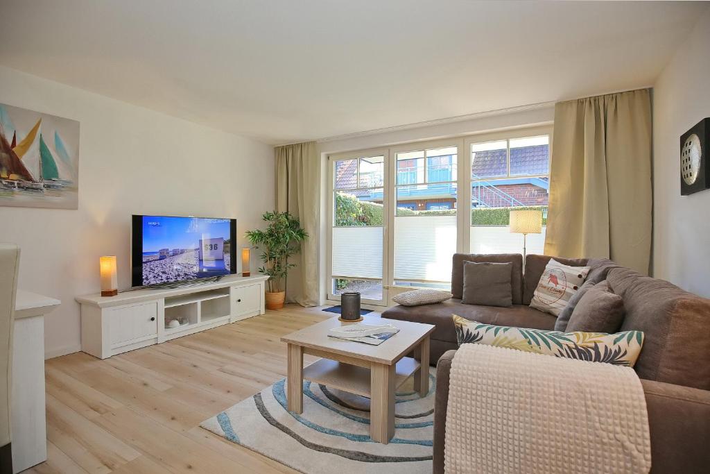 a living room with a couch and a tv at Papillon Wohnung 04-3 in Boltenhagen