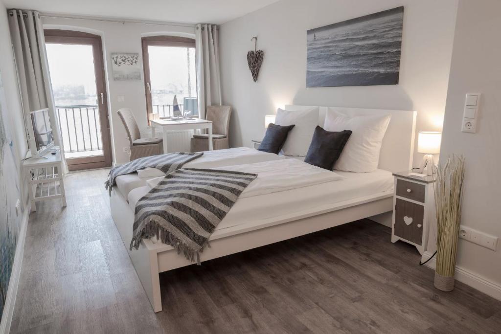 a bedroom with a large white bed with pillows at Gästehaus Von Herzen in Lauenburg