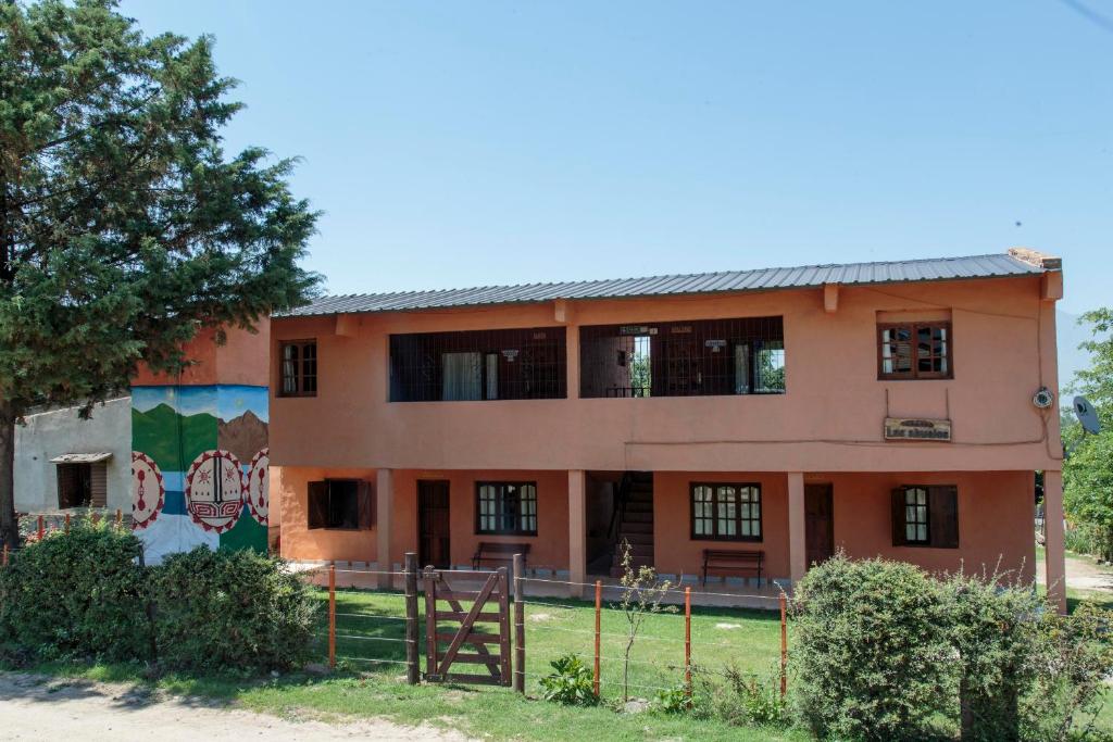 een oranje gebouw met een muurschildering bij Los Abuelos Departamentos in Tafí del Valle