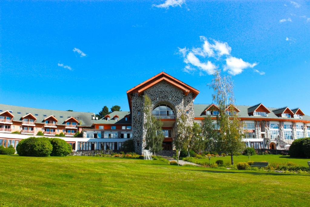 una vista esterna di un resort con prato verde di Hotel Termas Puyehue Wellness & Spa Resort a Puyehue