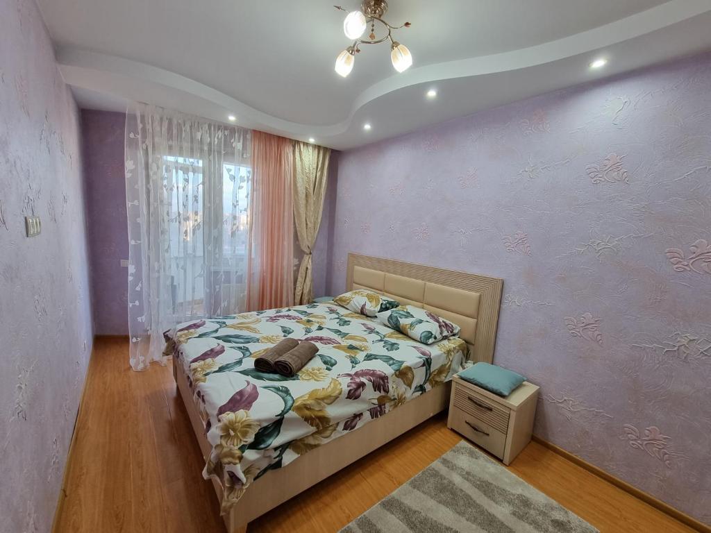 a bedroom with a bed and a purple wall at Rent Grand Delux Apartments Design in Chisinau in Chişinău