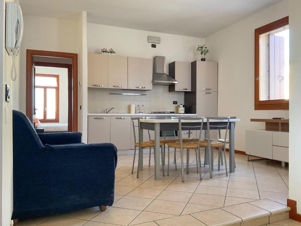 a kitchen with a table and chairs and a blue couch at Blue Apartment Conselve in Conselve