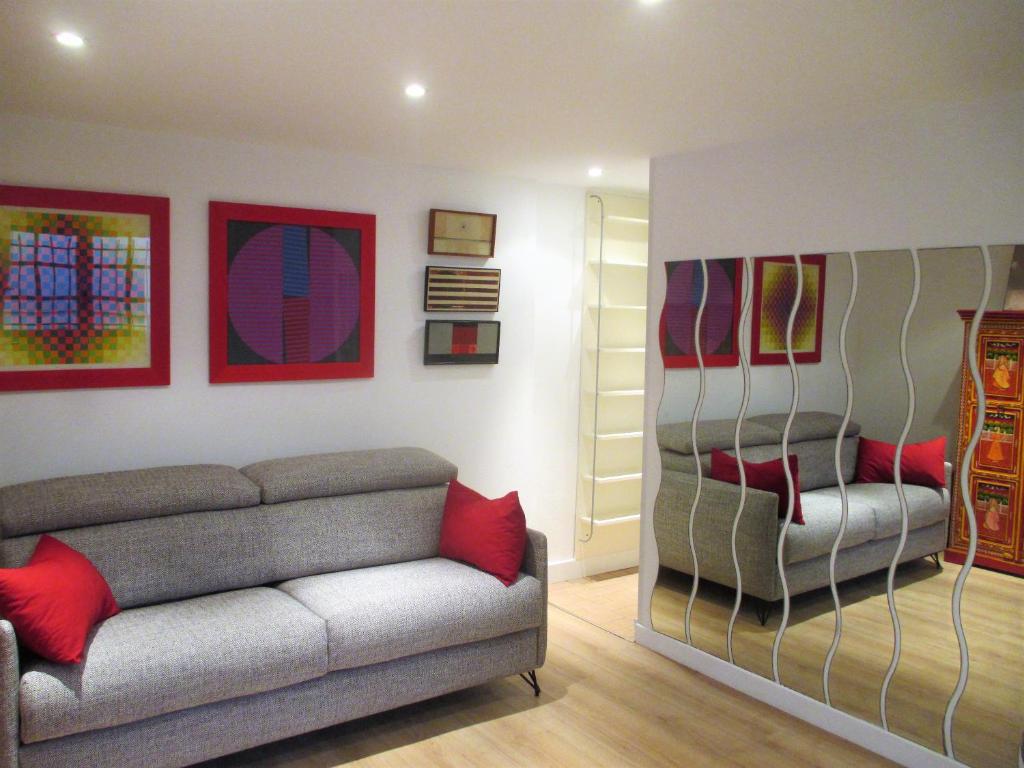 un salon avec un canapé et des tableaux au mur dans l'établissement Cosy studio au cœur du triangle d'or, à Le Touquet-Paris-Plage