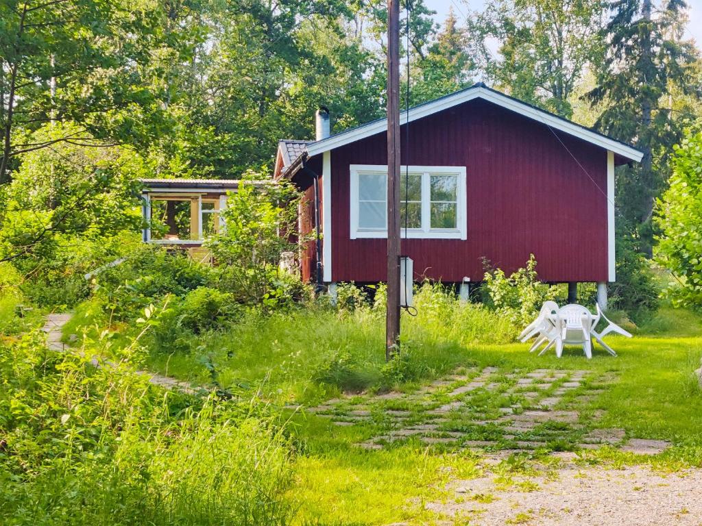 una casa roja con un banco delante en Peaceful nature retreat, en Björnlunda