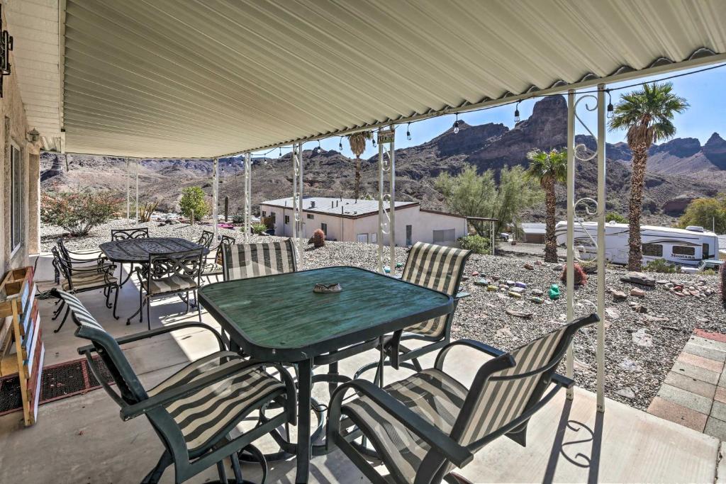 um pátio com uma mesa, cadeiras e montanhas em Sun-Dappled AZ Abode with River and Mtn Views! em Parker