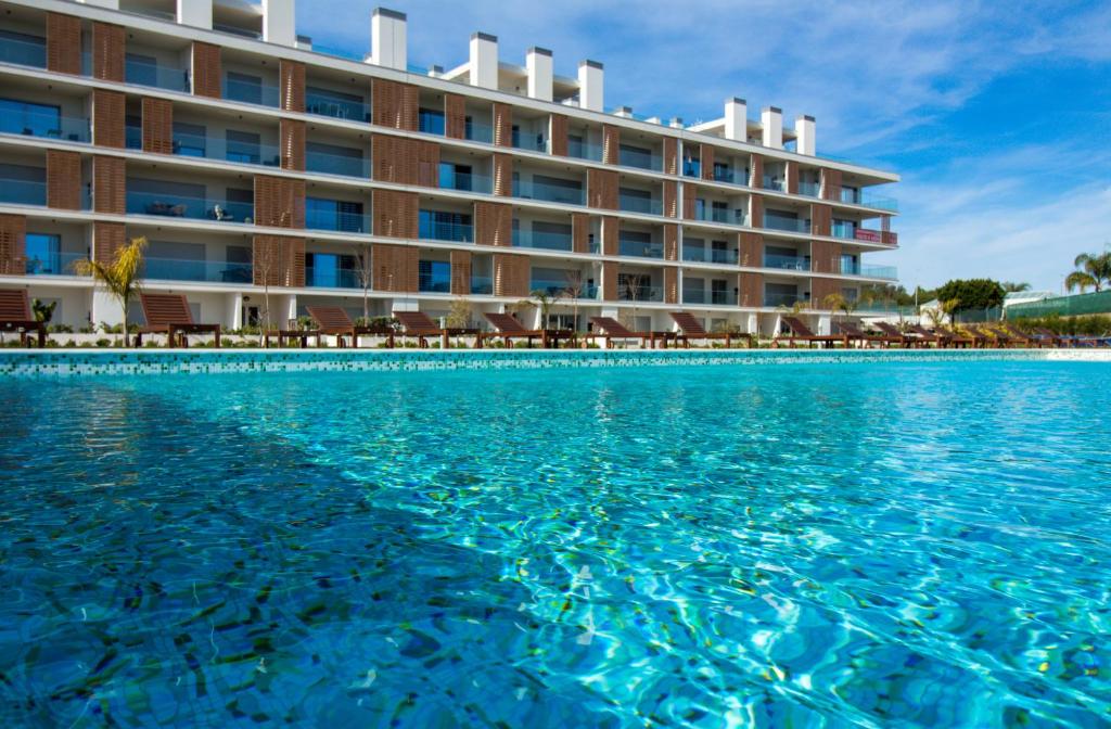 Blick auf das Hotel vom Pool aus in der Unterkunft Green Apartment - Luxurious & Pool & Garden & Playground & Garage in Albufeira