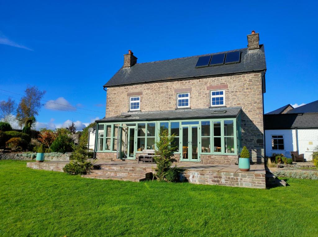 a large brick house with large windows and a lawn at Ty Newydd B&B in Brecon