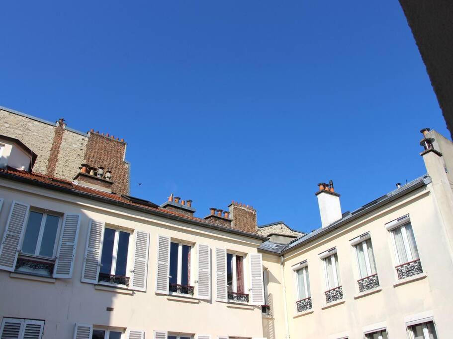 une rangée de bâtiments blancs avec fenêtres et toits dans l'établissement Paisible appartement aux portes de Paris, à Vincennes