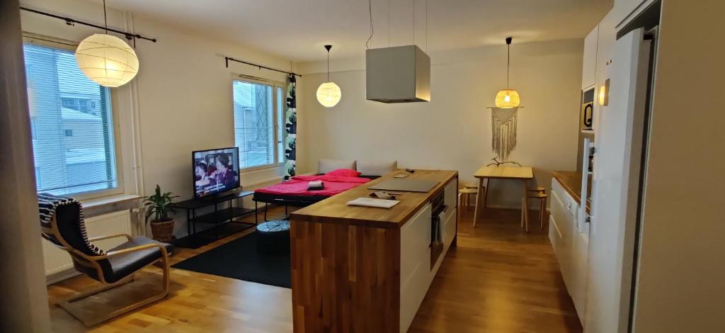 a kitchen and living room with a table and a couch at City center apartment with sauna, Rovakatu 13 in Rovaniemi