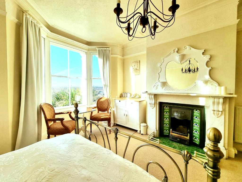 a bedroom with a bed and a fireplace at West Hill Retreat Edwardian Balcony Grand Ensuite with Room Served Breakfast & Free Offstreet Parking in Hastings