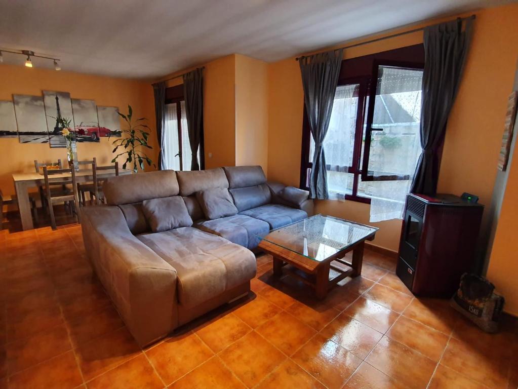 uma sala de estar com um sofá e uma mesa em Casa rural en la Sierra Norte de Madrid em Manjirón