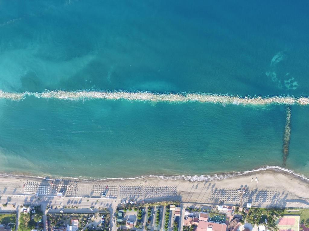 eine Luftansicht auf einen Strand mit Gebäuden und das Meer in der Unterkunft Villaggio Turistico Elea in Ascea