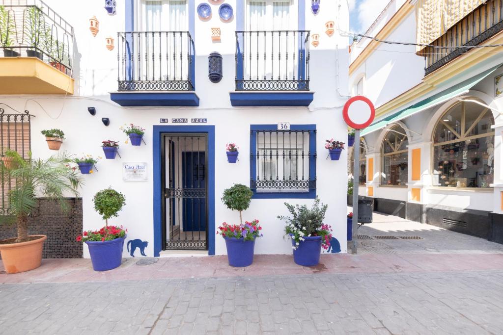 um edifício branco com vasos de plantas numa rua em CASA AZUL - Boutique Apartments by Casa del Patio em Estepona