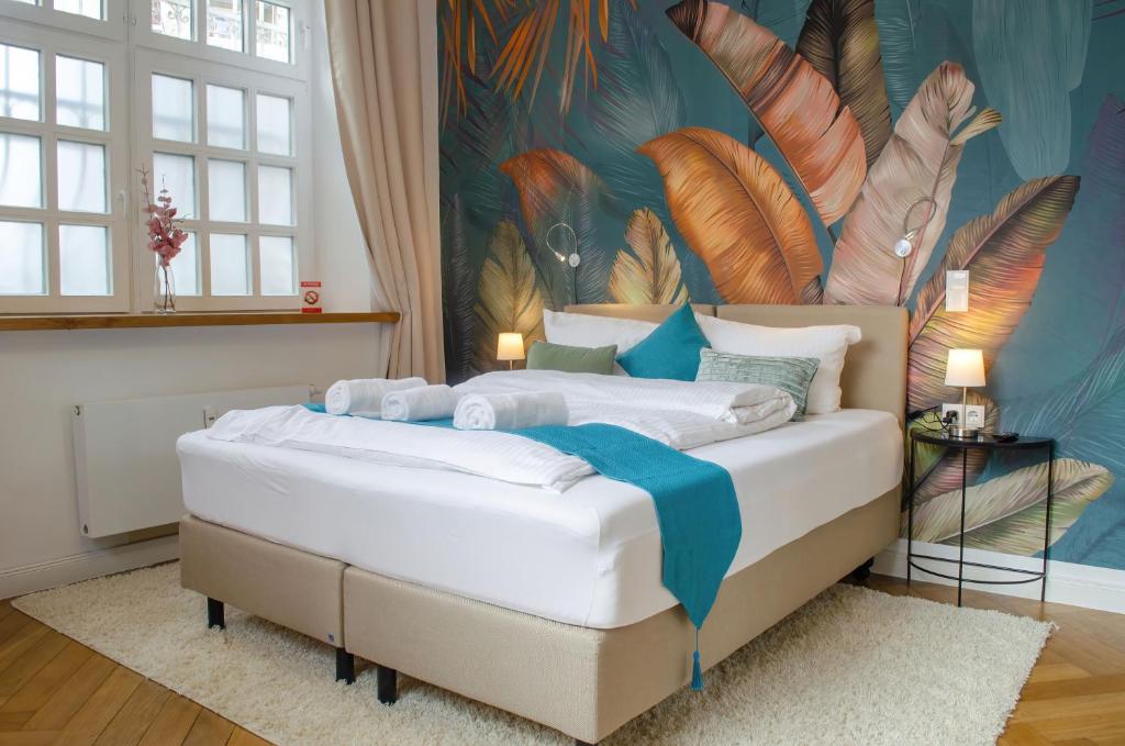 1 dormitorio con 1 cama con un mural de plumas en HOMELY STAY Studio 4, en Múnich