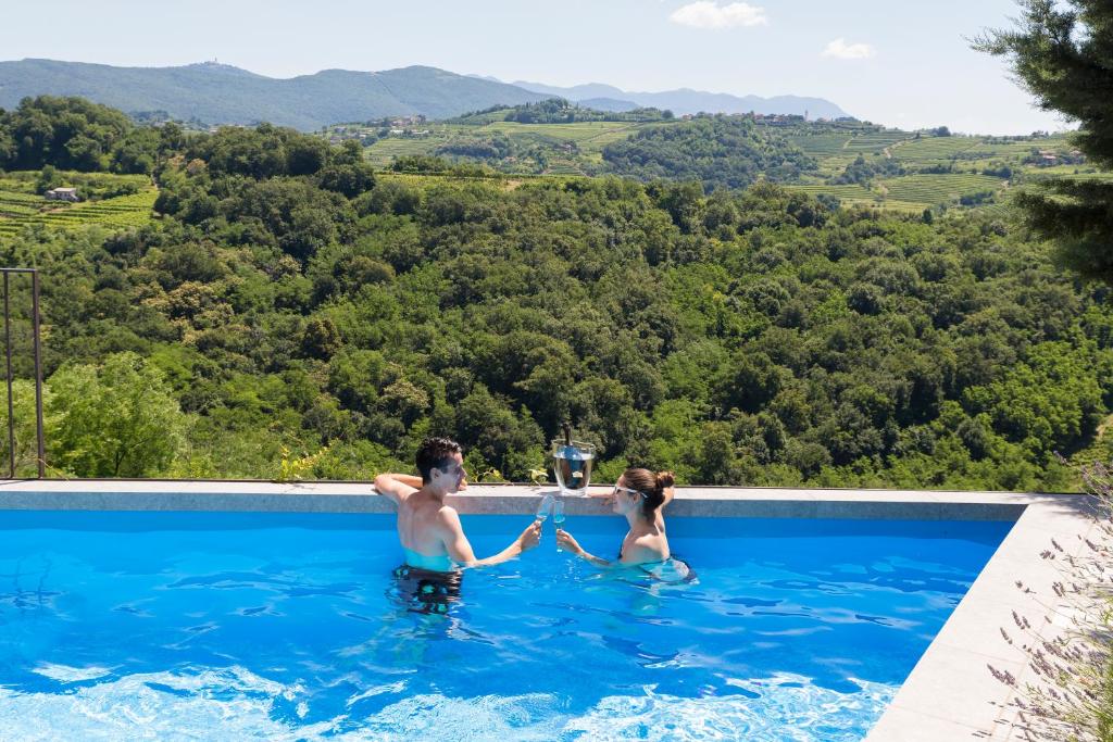 Un uomo e una donna in piedi in una piscina di Villa EVA a Dobrovo