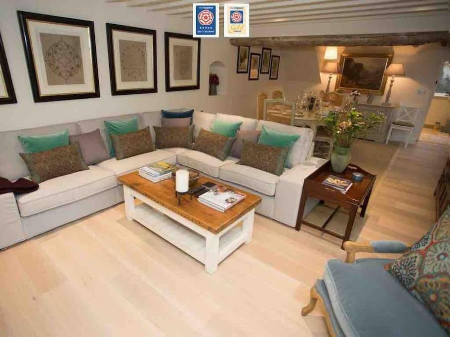 ボートン・オン・ザ・ウォーターにあるCraigmoor Cottageのリビングルーム(白いソファ、テーブル付)