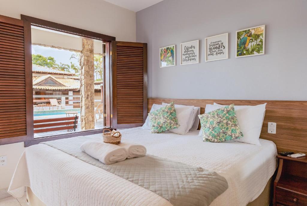 sypialnia z łóżkiem z ręcznikami w obiekcie Pousada Algodão da Praia w mieście Araruama