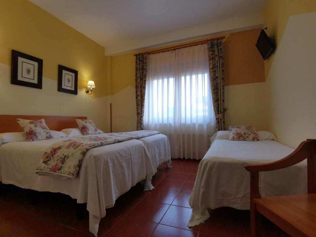 Postel nebo postele na pokoji v ubytování Hotel El Angliru