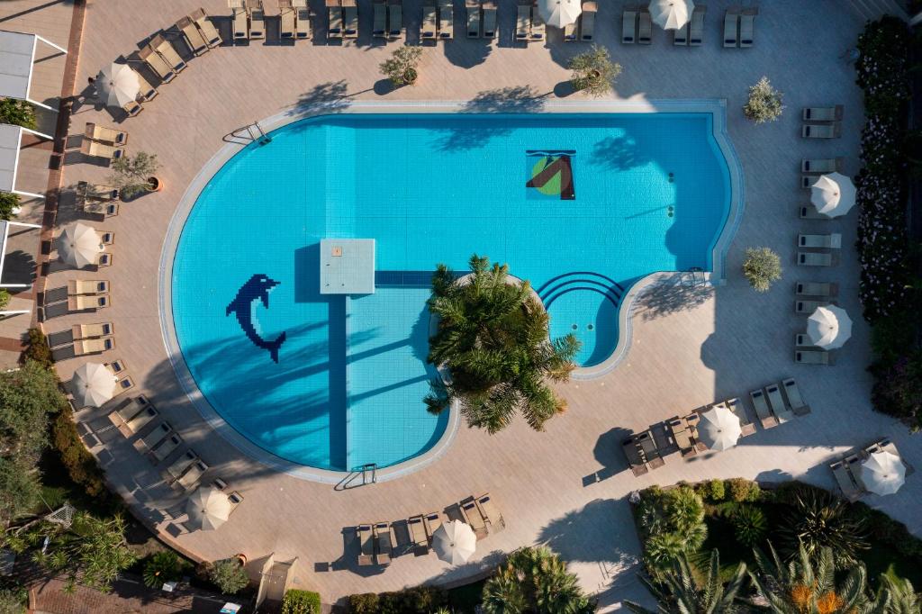 an overhead view of a large swimming pool with chairs at Vascellero Club Resort in Cariati