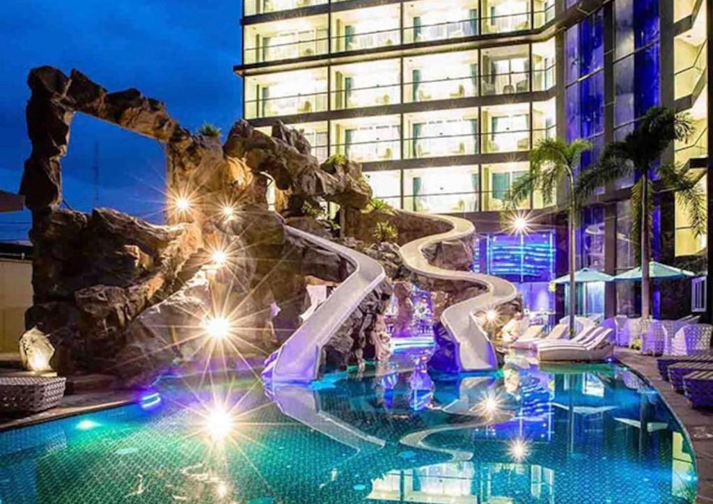 a pool in front of a building at night at Centara Avenue Residence By Daisy Pattaya 1 in Pattaya Central