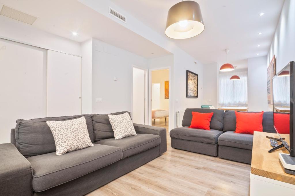 a living room with a gray couch and red pillows at Barcelona Eixample in Barcelona
