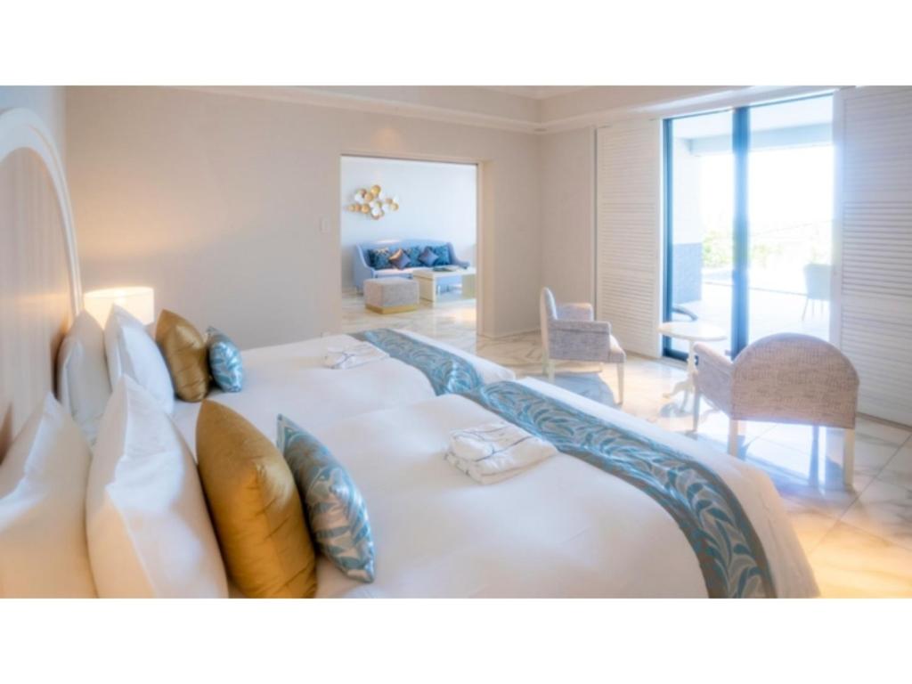 una sala de estar con una gran cama blanca con almohadas en Miyakojima Kurima Resort Seawood Hotel - Vacation STAY 16229v, en Uechi