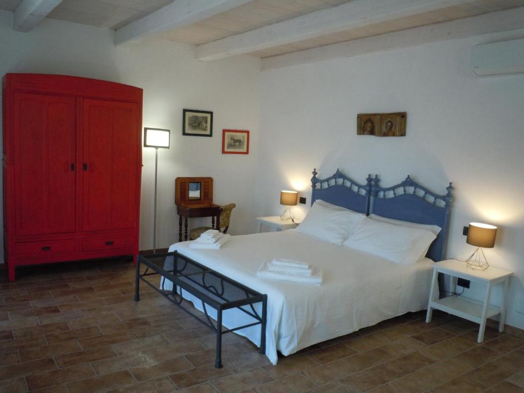 a bedroom with a large bed and a red cabinet at Antica Cascina Pilo in Monchiero