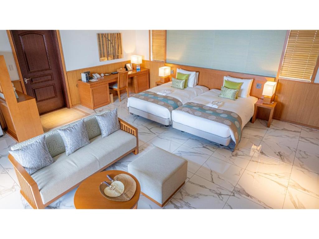 UechiにあるMiyakojima Kurima Resort Seawood Hotel - Vacation STAY 16227vのベッド2台とソファが備わるホテルルームです。