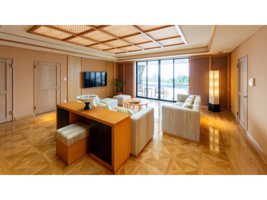 een woonkamer met een bank en een tafel bij Miyakojima Kurima Resort Seawood Hotel - Vacation STAY 16225v in Uechi