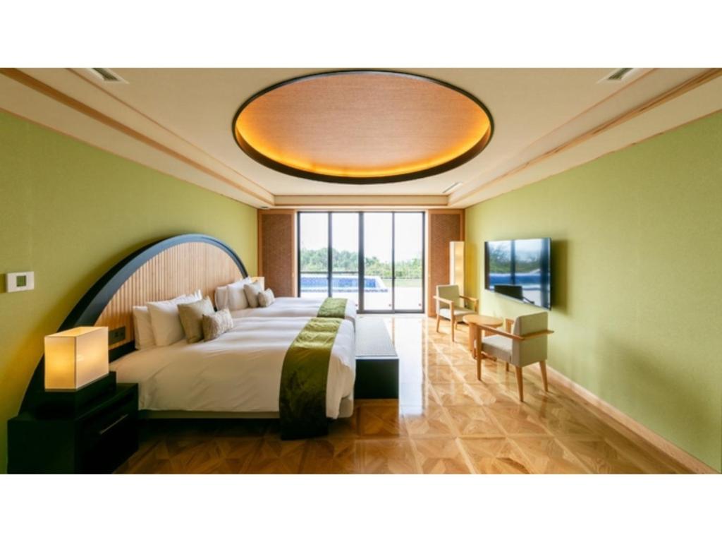 um quarto com uma cama grande e uma janela grande em Miyakojima Kurima Resort Seawood Hotel - Vacation STAY 16224v em Uechi