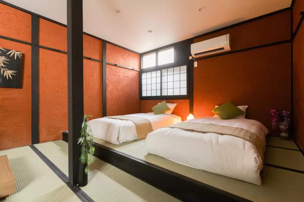 a bedroom with two beds and a window at Oyado NAKAZ1 - Vacation STAY 27690v in Osaka