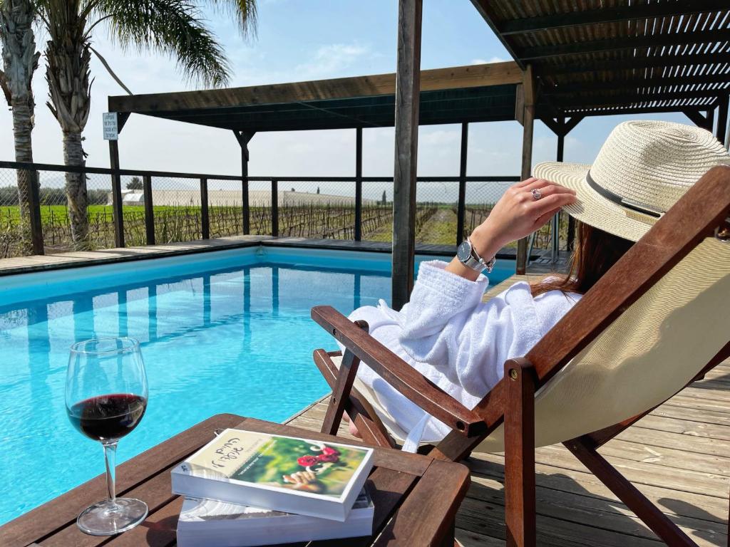 a woman sitting in a chair with a glass of wine at Bar Bakfar in Sharona