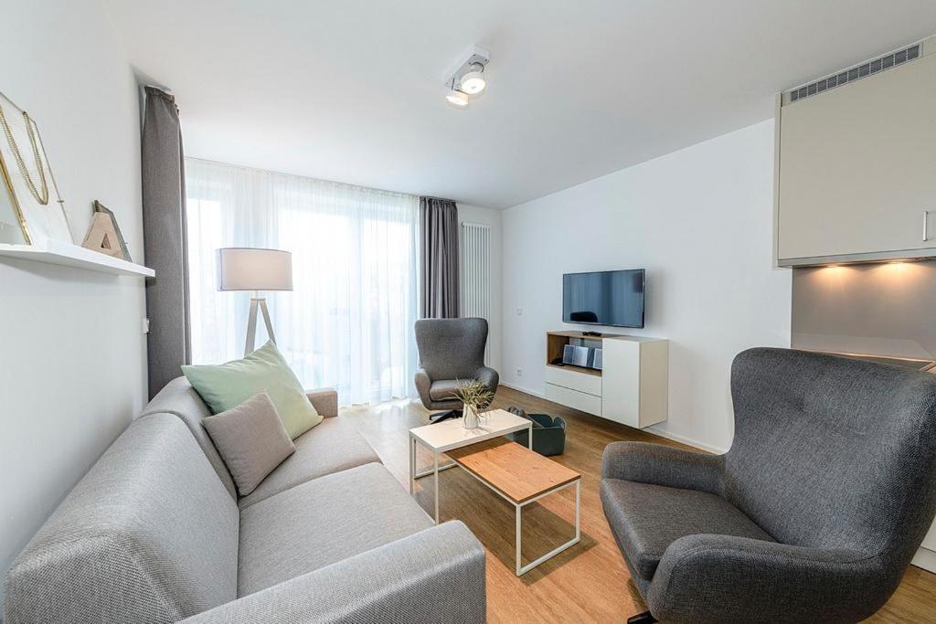 ein Wohnzimmer mit einem Sofa und zwei Sesseln und einem Fernseher in der Unterkunft Apartmentvilla Anna See Apartmentvilla Anna See 1-11 in Langeoog