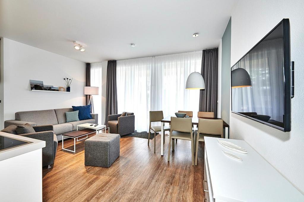 ein Wohnzimmer mit einer Couch und einem Tisch mit Stühlen in der Unterkunft Deichhäuser Anna Küste Deichhäuser Anna Küste 4-13 in Bensersiel