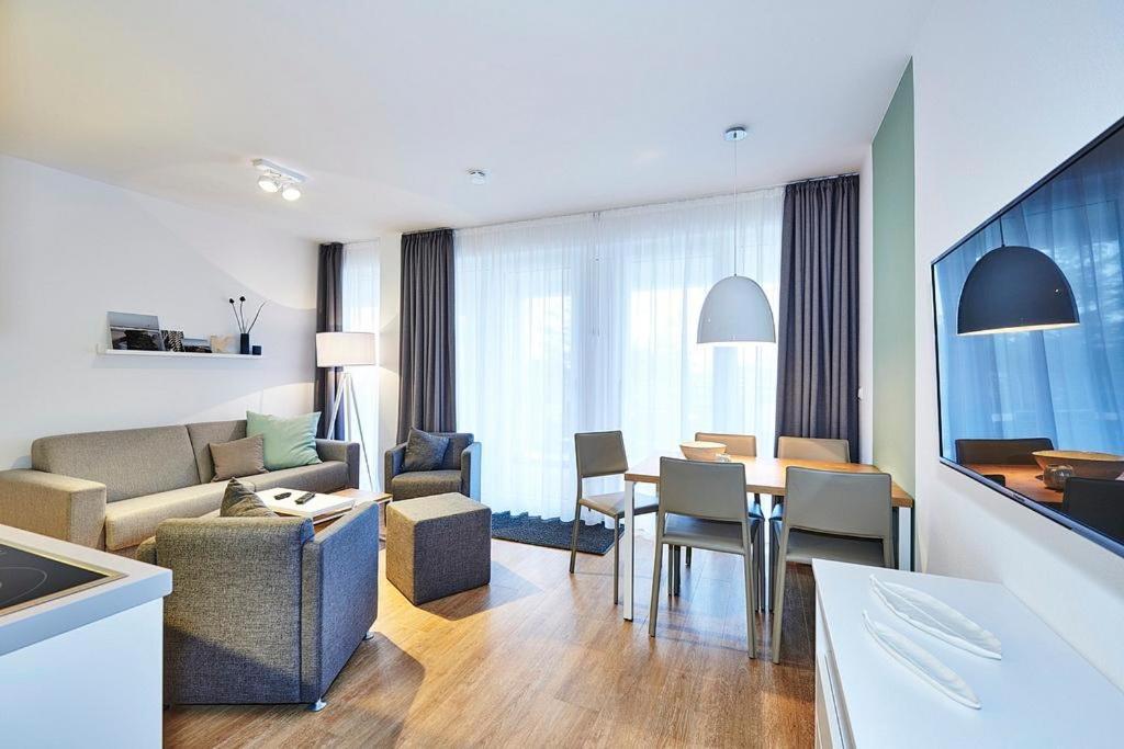 ein Wohnzimmer mit einer Couch und einem Tisch mit Stühlen in der Unterkunft Deichhäuser Anna Küste Deichhäuser Anna Küste 4-23 in Bensersiel