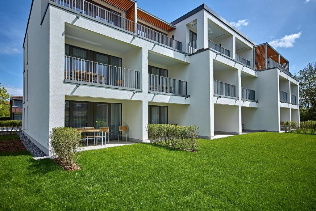 an apartment building with a lawn in front of it at Deichhäuser Anna Küste Deichhäuser Anna Küste 7-22 in Bensersiel