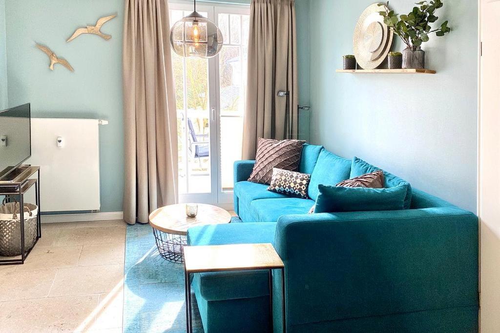 a living room with a blue couch and a table at Dünenschloss Dünenschloss 2-16 in Kühlungsborn