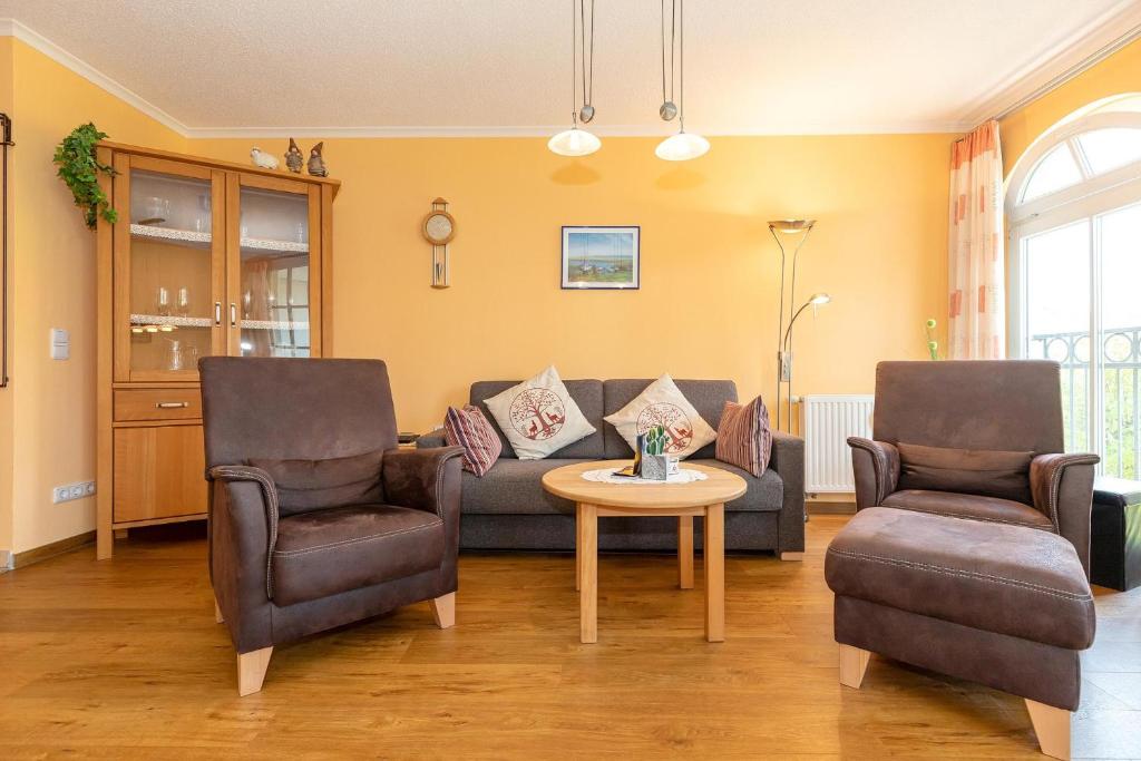 uma sala de estar com um sofá e duas cadeiras e uma mesa em Apartmenthaus Atlantik Apartmenthaus Atlantik 205 em Kühlungsborn