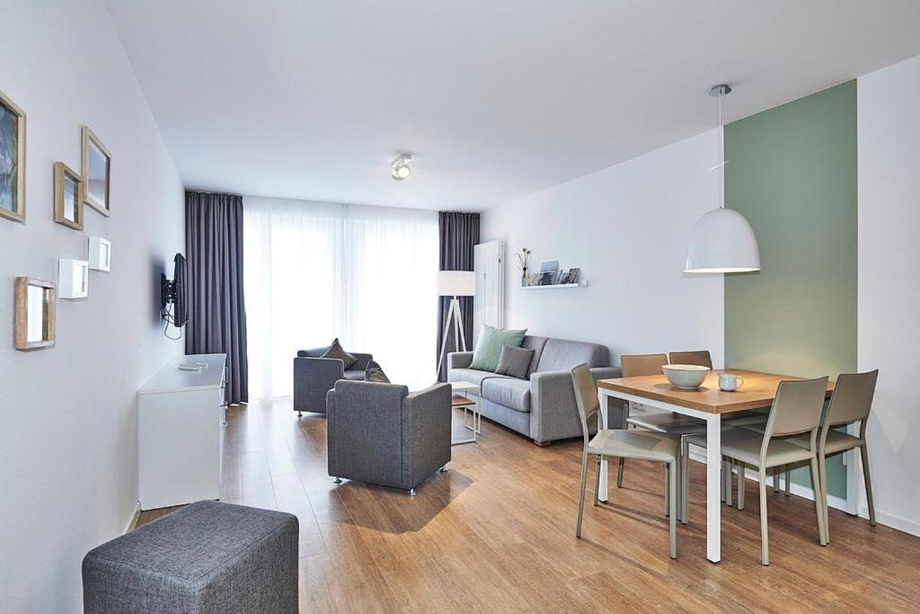 un salon avec une table et un canapé dans l'établissement Deichhäuser Anna Küste Deichhäuser Anna Küste 4-30, à Bensersiel